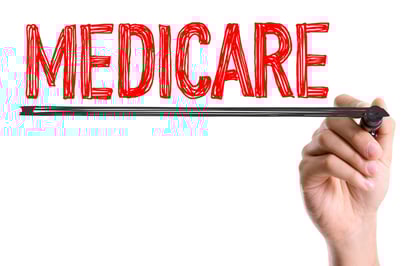 Hand with marker writing the word Medicare